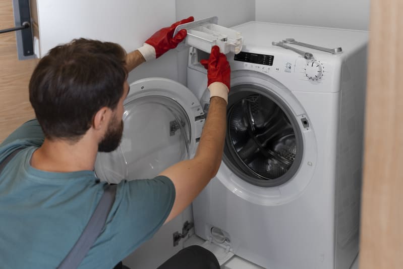 Technician repairing a home appliance with tools organized