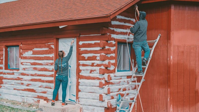 Painter taping edges and rolling walls